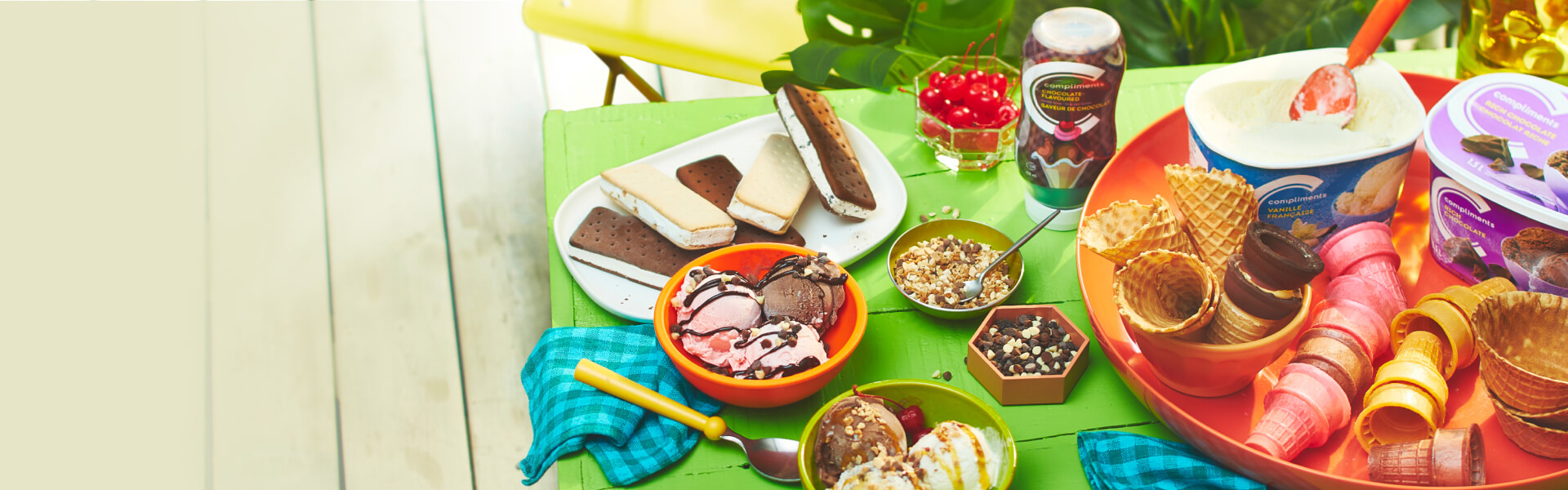 Backyard table setting for an ice cream party, with full ice cream sundae bar and ice cream party supplies