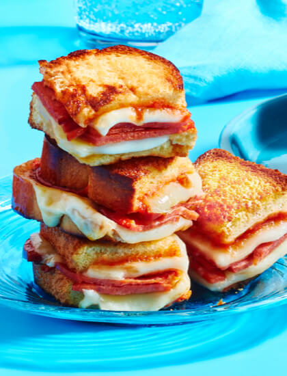 Salsa grilled cheese sandwich, pizza grilled cheese sandwich, ad corn-herb grilled cheese sandwich on blue plates