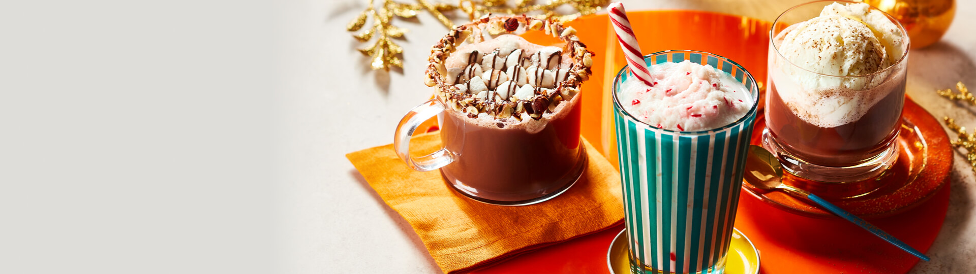 Photo of hazelnut hot chocolate, frozen white hot chocolate, and whipped white hot chocolate over coffee