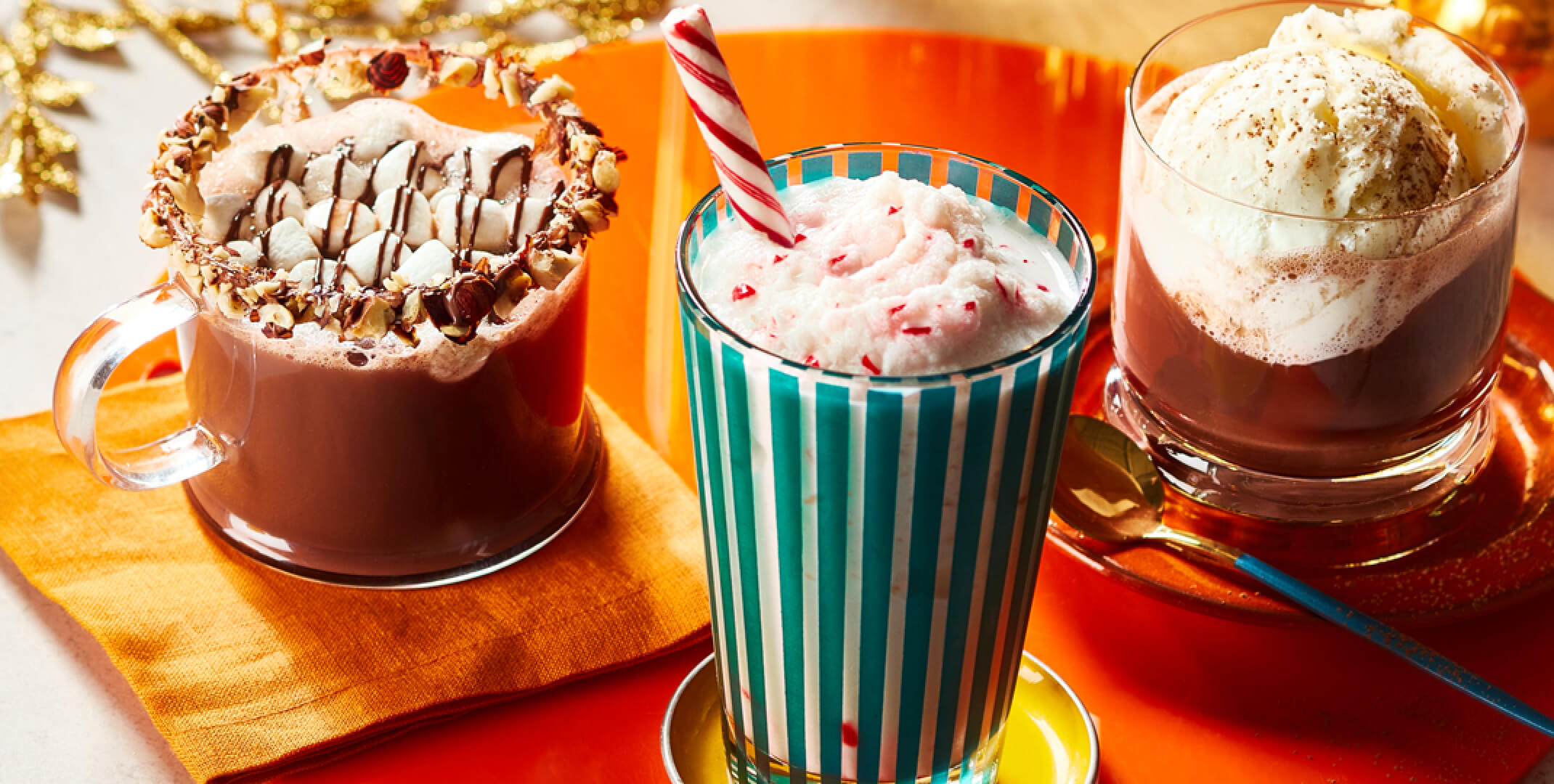 Photo of hazelnut hot chocolate, frozen white hot chocolate, and whipped white hot chocolate over coffee