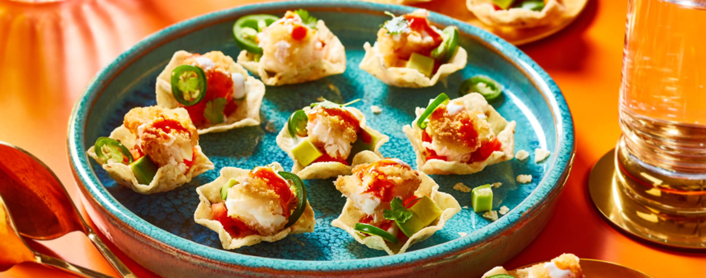 Plate of fish taco bites on orange table