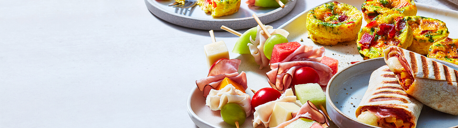 White platter with frittta, kebobs, and pizza wrap